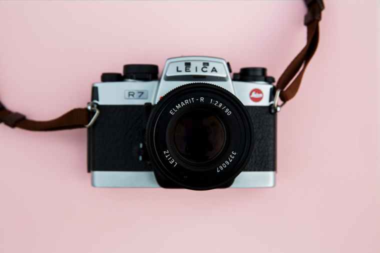 black and grey leica camera on pink background