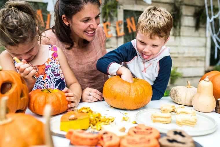 person holding pumpkin beside woman